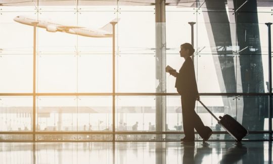A woman with a suitcase at an airport