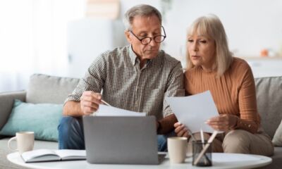 A couple looks at documents and a laptop representing why is my super going down?