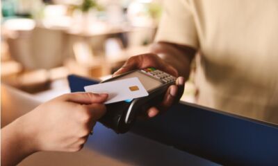 person tapping credit card on automated machine BNPL