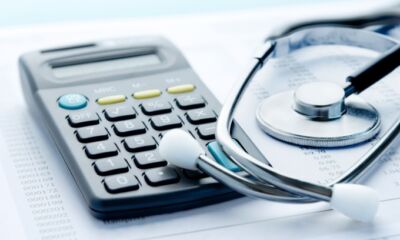 A calculator and stethoscope representing health insurance price hike.