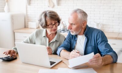 An elderly couple consider their loan options representing personal loan for pensioners.