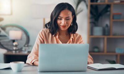 A woman looks at her laptop reading a Product Disclosure Statement.